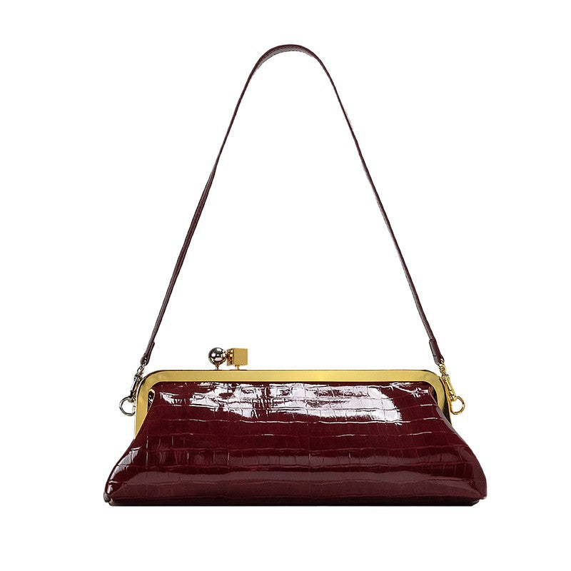 Strukturierte Clutch mit Kiss-Lock-Rahmenverschluss aus dunkelbrauner, krokodil-geprägter Lederoptik mit goldfarbenen Details und schmalem
