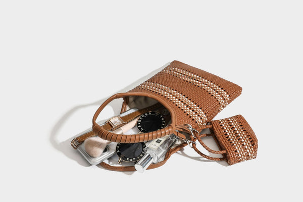 Color-block woven tote bag with rounded leather-look handles, detachable crossbody strap, and matching mini clip-on pouch in