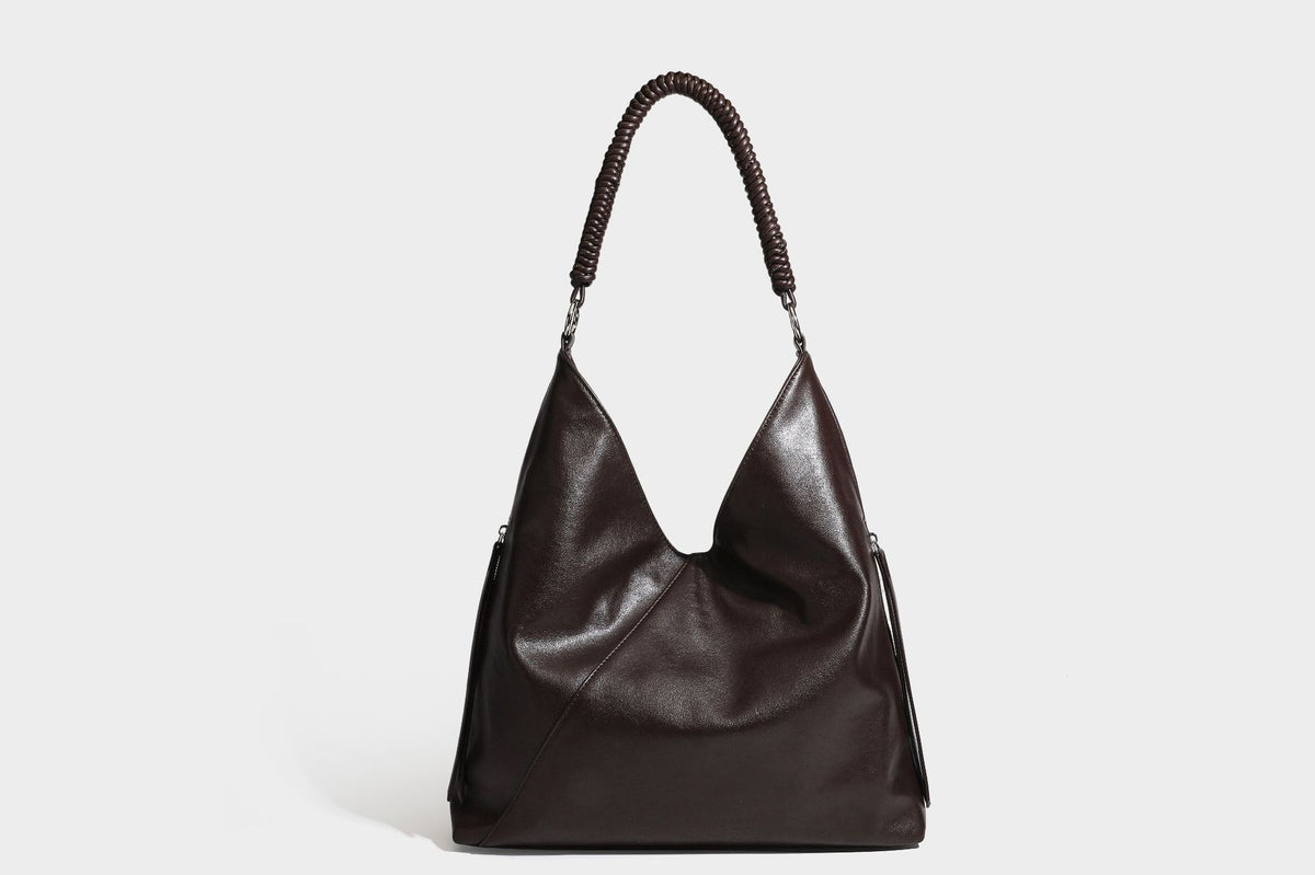 Large slouchy hobo shoulder bag with braided top handle, smooth glossy leather-look finish, and silver-tone ring hardware