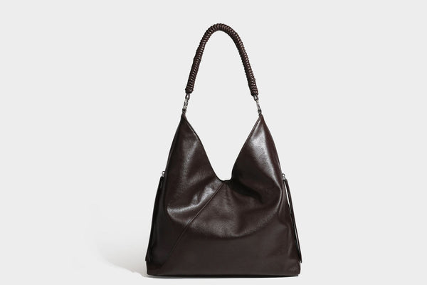 Large slouchy hobo shoulder bag with braided top handle, smooth glossy leather-look finish, and silver-tone ring hardware