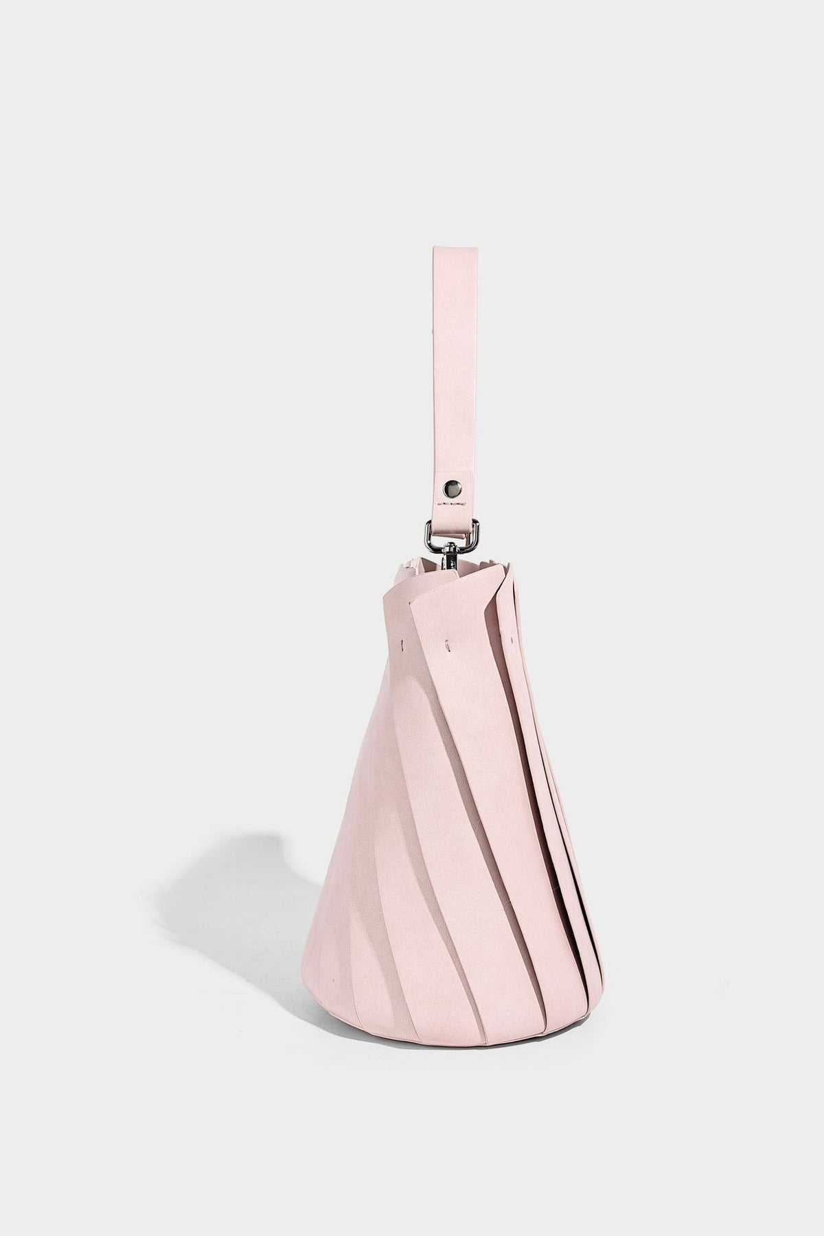 Structured pleated-panel bucket bag with curved top handle and detachable adjustable shoulder strap in smooth matte, detail