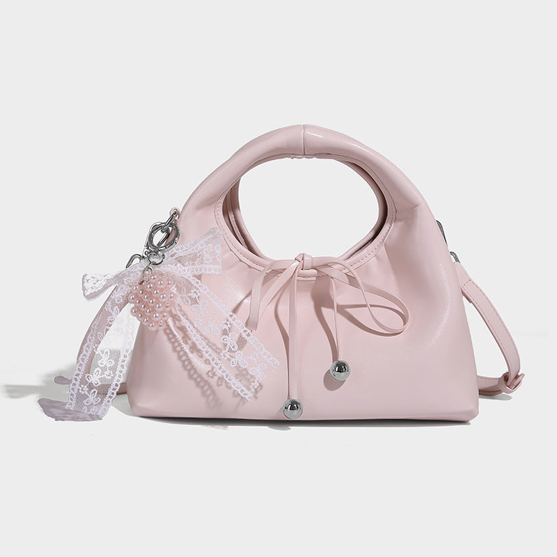 Kleine glänzende kuppelförmige Henkeltasche in Lederoptik mit Zugbandverschluss, weißem Spitzen-Schleifenanhänger und silberfarbenen Beschlägen