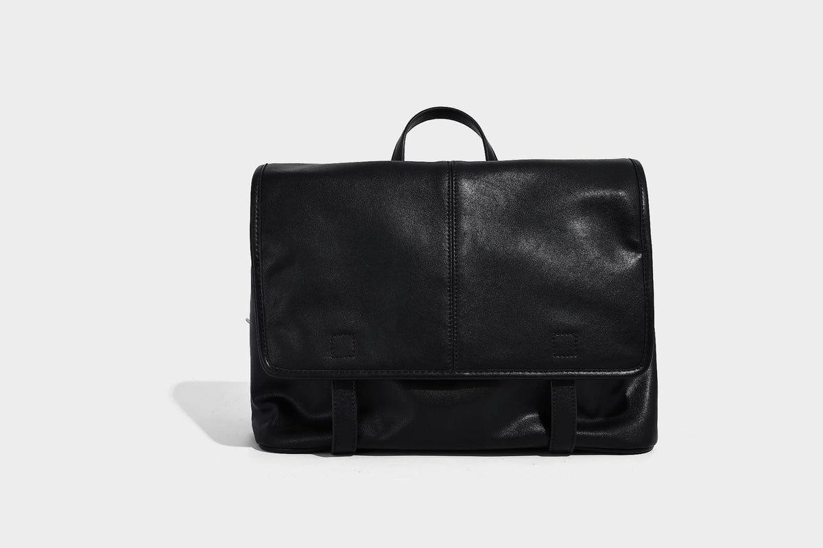 Structured tan leather-look flap backpack handbag with top handle, silver buckle hardware, and fold-over front closure