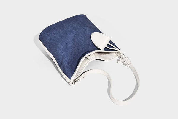 Große Bucket-Schultertasche aus Canvas in Denim-Optik mit Besatz in weißer Lederoptik, geknotetem Riemen und abnehmbarer Mini-Tasche auf der Vorderseite