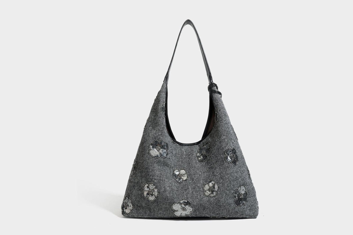 Lässig fallende, trapezförmige Schulter-Tote in Anthrazitgrau mit floralen Paillettenmotiven in Silber, Riemen in Lederoptik und herabhängendem Perlenbesatz