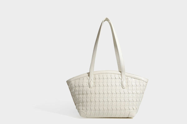 Large leather-look tote bag with geometric woven emboss, double shoulder straps, and round woven cord charm in brown, detail