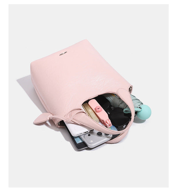 Soft glossy leather-look bucket tote bag with twin handles and detachable crossbody strap, detail view 14