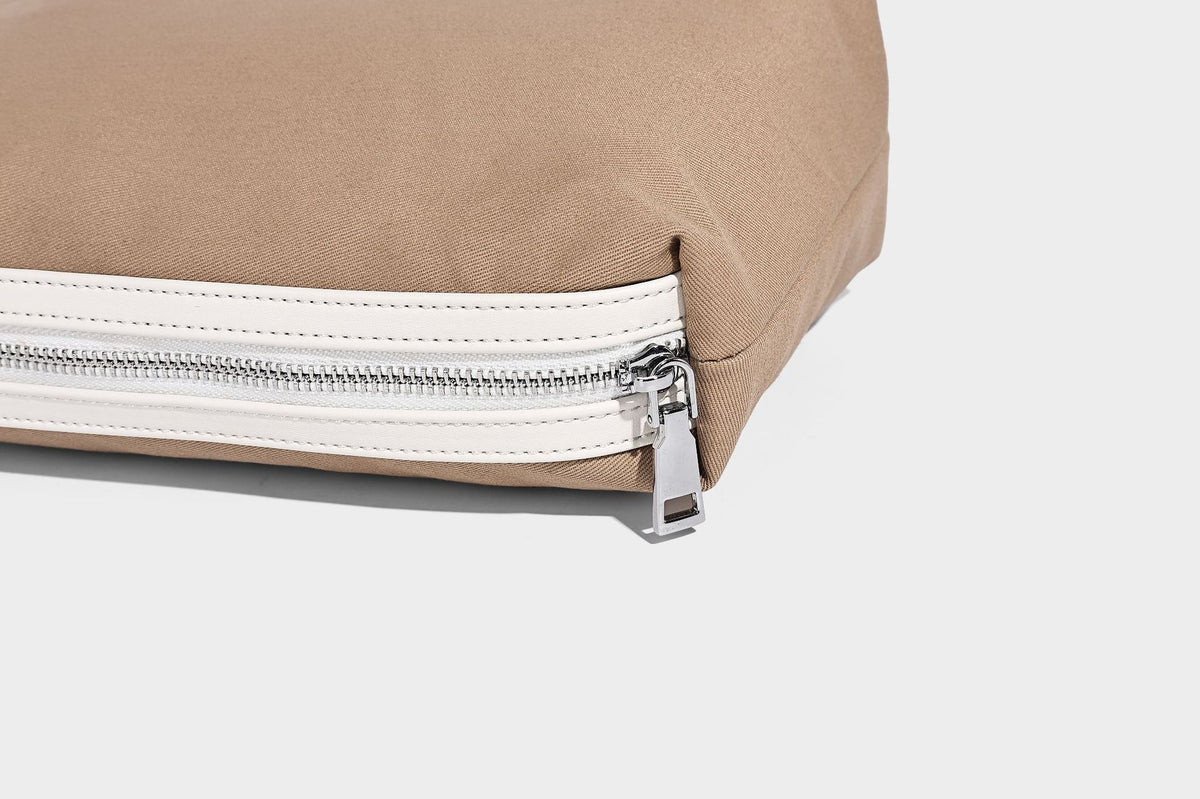 Denim-blue hobo tote with white leather-look shoulder strap, contrast whipstitch trim along curved open top, and silver-tone