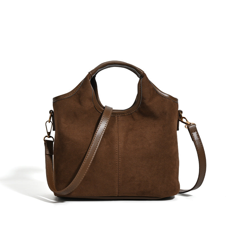 Wandelbarer Shopper in mattem Schokoladenbraun mit Velourslederoptik, abgerundeten Henkeln und abnehmbarem Schulterriemen, goldfarbene Details