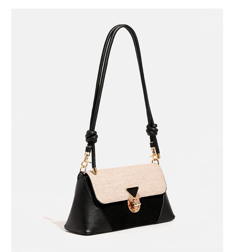 Structured trapezoid shoulder bag with pale textured flap, gold-tone triangular turn-lock closure, and long knotted cord