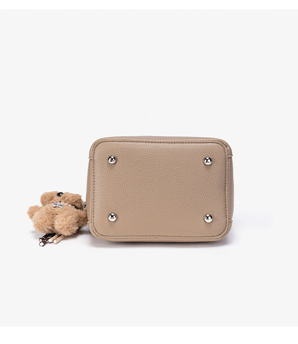 Compact structured bucket bag in pebbled leather-look finish with silver turn-lock front clasp, dual top handles, detachable