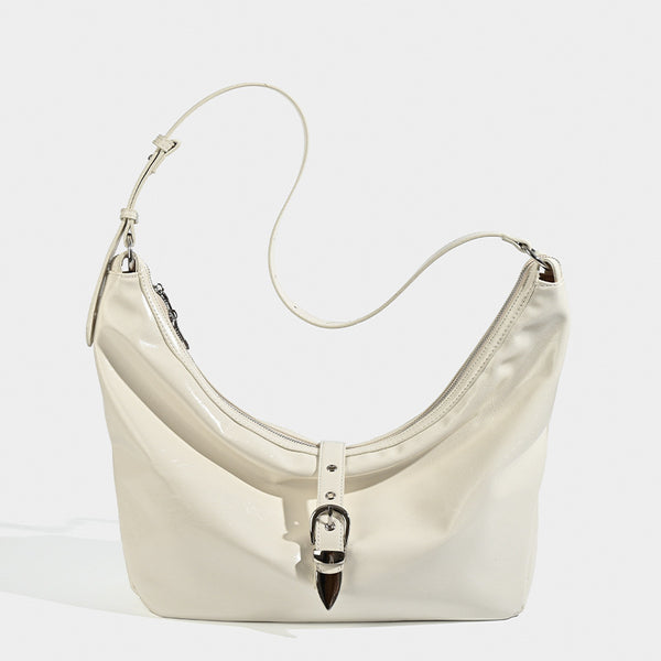 Slouchy crescent hobo bag with glossy leather-look finish, silver-tone buckle hardware, and flat shoulder strap, detail view