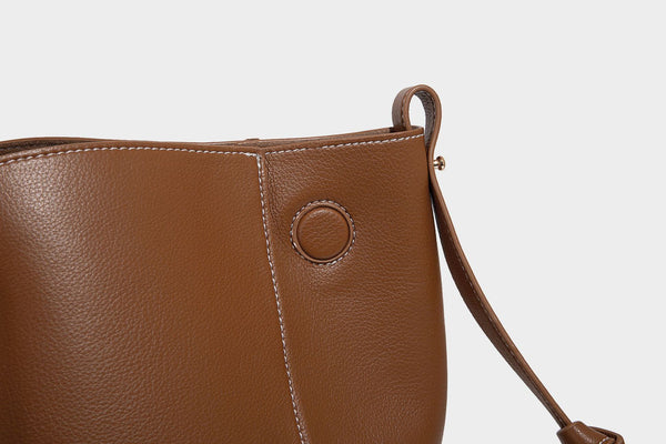 Große, formstabile trapezförmige Tote-Bag aus braunem Lederimitat mit genarbter Oberfläche, zwei Tragegriffen und seitlichen Bindebändern, Detail