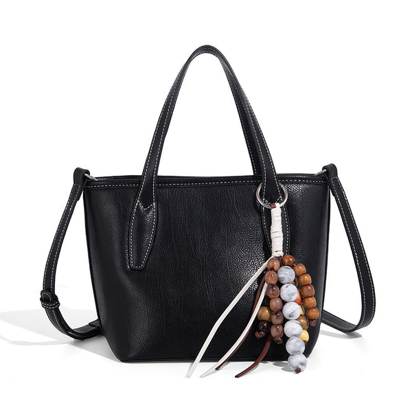 Compact structured bucket tote bag with pebbled textured finish, dual top handles, silver-tone lock hardware, and detachable