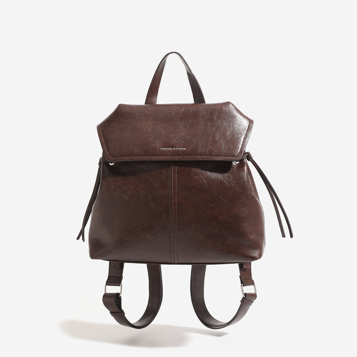 Structured flap-top backpack handbag in distressed leather-look finish with side drawstring ties and silver hardware, detail