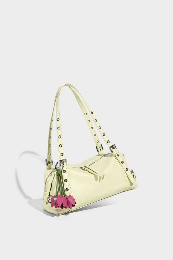 Pale yellow leather-look barrel bag with silver grommet-studded shoulder straps, top zip closure, and pink tulip floral