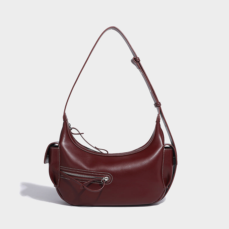 Smooth leather-look crescent shoulder bag with front zip pocket, side flap pockets, adjustable strap, and silver-tone, detail