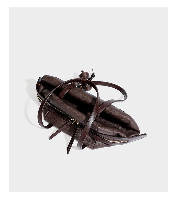 Structured trapezoid shoulder bag in dark brown pebbled leather-look finish with slim double straps, top zip closure, side