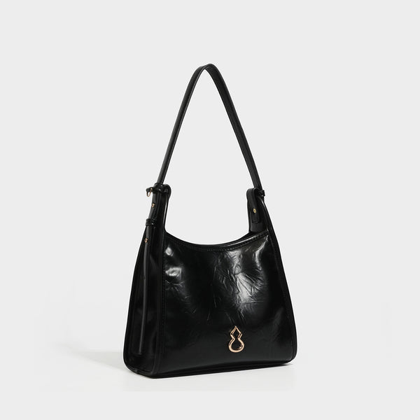 Strukturierte Trapez-Schultertasche mit glänzender, geknitterter Oberfläche in Lederoptik, goldfarbenen Beschlägen an der Vorderseite und langem, verstellbarem