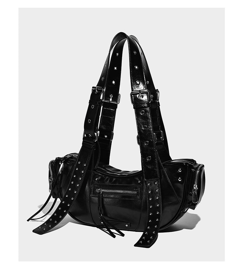 Glossy black crescent shoulder bag with silver-tone rivets, multiple zip pockets, and long adjustable studded straps, detail