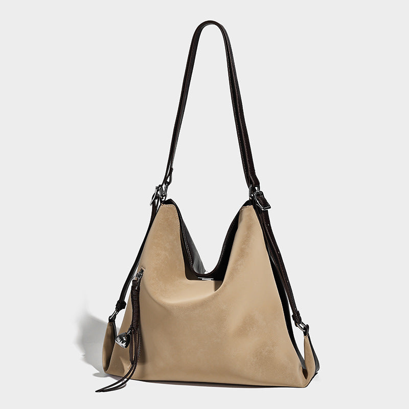 Slouchy hobo tote bag with matte leather-look finish, triangular silhouette, front zip pocket, and adjustable shoulder strap