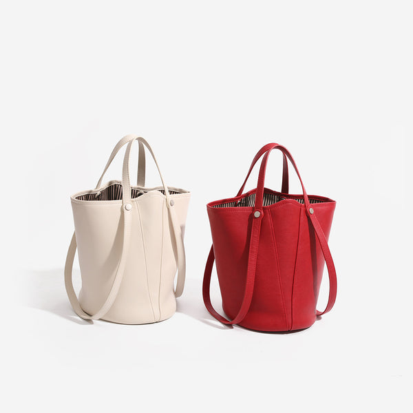 Large leather-look bucket tote bag with dual top handles and adjustable crossbody strap, detail view 2