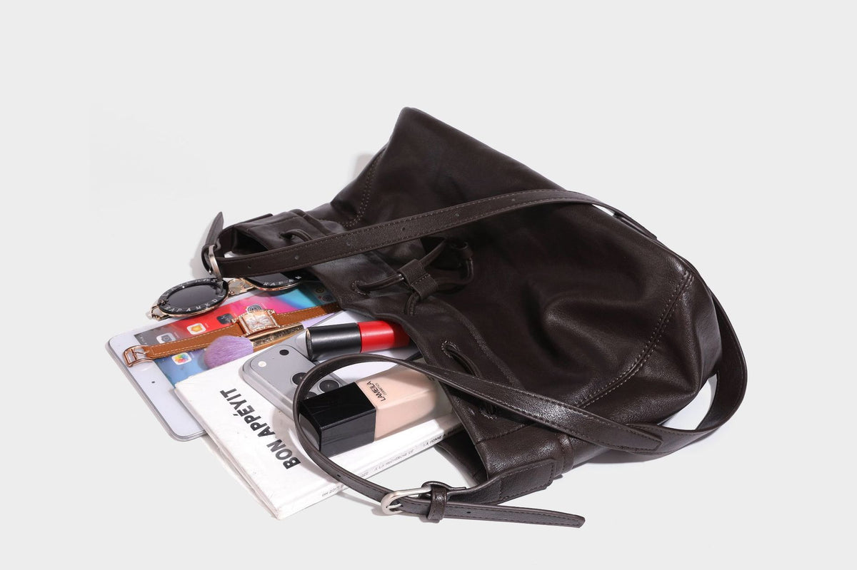Lässig fallende Beuteltasche mit Kordelzug in dunkler Espresso-Lederoptik, verstellbarem Riemen und Ringbeschlägen aus Metall