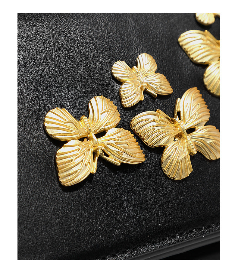 Slim rectangular crossbody bag with gold-tone butterfly metal appliqués and fine antiqued chain strap, detail view 11