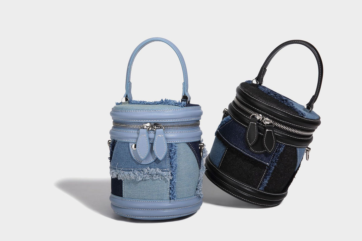 Mini cylindrical barrel bucket bag in denim patchwork with frayed edges, smooth leather-look trim, zip-around top closure