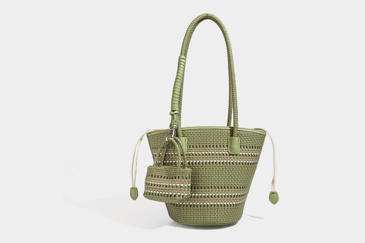Light blue open-weave woven bucket tote bag with long braided shoulder straps, drawstring side ties, and attached mini pouch