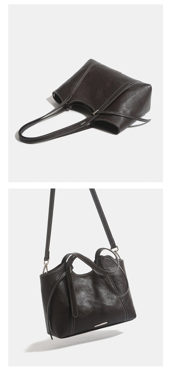 Structured leather-look tote shoulder bag with double crossed straps, contrast topstitching, and metal bar hardware, detail
