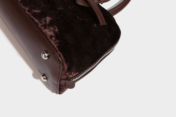 Small structured satchel bag in dark brown velvet-like textured finish with leather-look trim, silver-tone turn-lock bar