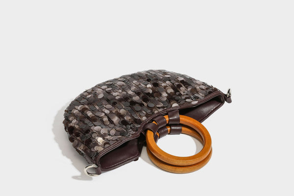 Small sequin half-moon handbag with circular wood-look ring handles and detachable leather-look shoulder strap, detail view