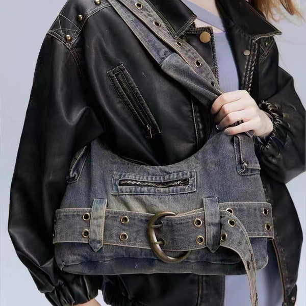 Washed blue-gray denim slouchy hobo shoulder bag with wide grommeted belt panel, brass-tone D-ring buckle, exterior zip