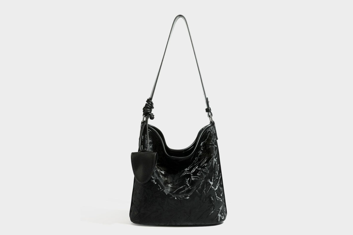 Große Hobo-Schultertasche mit Crinkle-Glanzfinish in Dunkelbraun, schmalem verstellbarem Riemen, geknoteten Beschlägen und seitlich befestigter Klappe