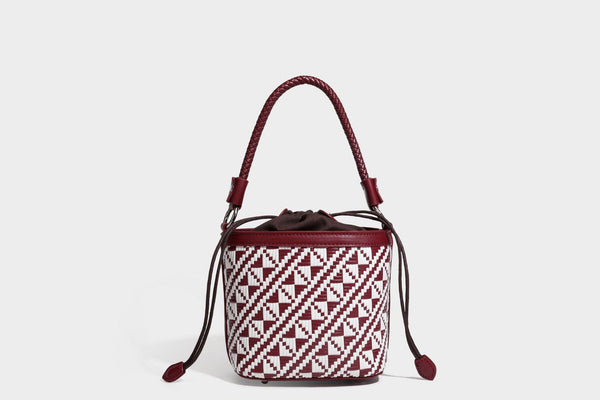 Kleine gewebte geometrische Bucket-Bag mit geflochtenem Henkel in Lederoptik und Kordelzugverschluss im zweifarbigen Muster aus Braun und Weiß