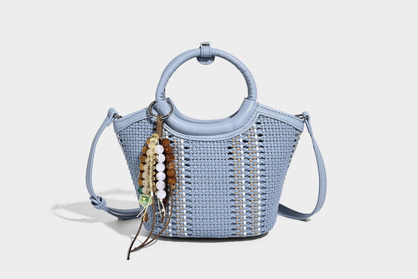 Kleine strukturierte Beuteltasche aus geflochtenem Material mit rundem Tragegriff in Lederoptik, silberfarbenen Beschlägen und perlenbesetztem Quastenanhänger, Detail