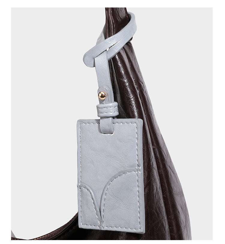 Große dunkelbraune, glänzende, geknautschte Hobo-Schultertasche mit Reißverschluss, goldfarbenen Beschlägen, verstellbarem Riemen und hellblauem