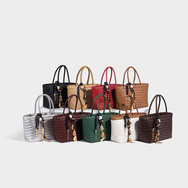 Structured chevron woven leather-look tote bag with braided top handles, gold feather charm, and adjustable shoulder strap