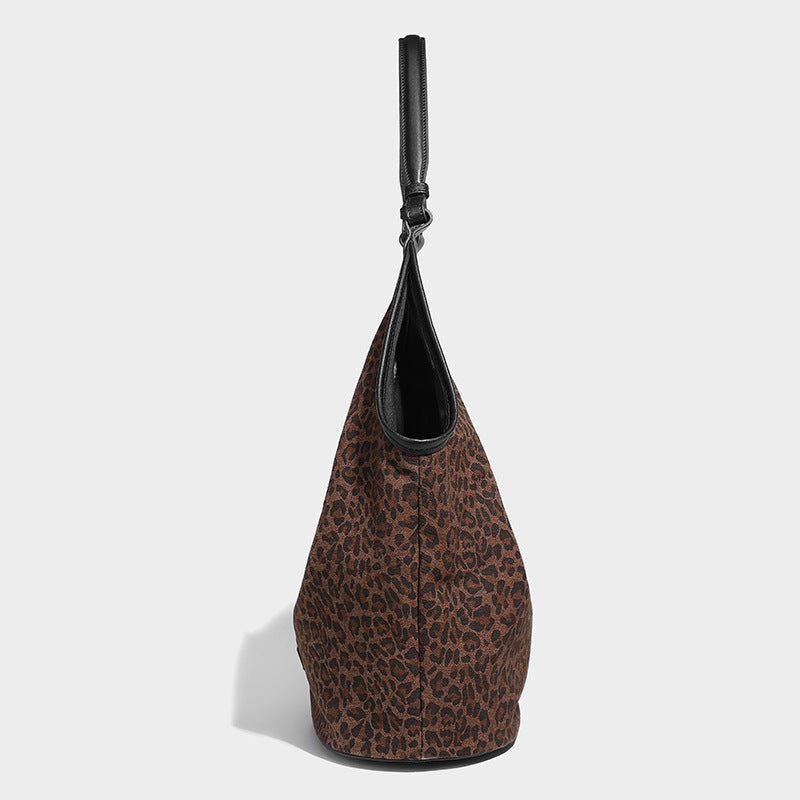 Slouchy brown leopard jacquard hobo tote bag with black leather-look trim and single shoulder strap, shown with black, detail