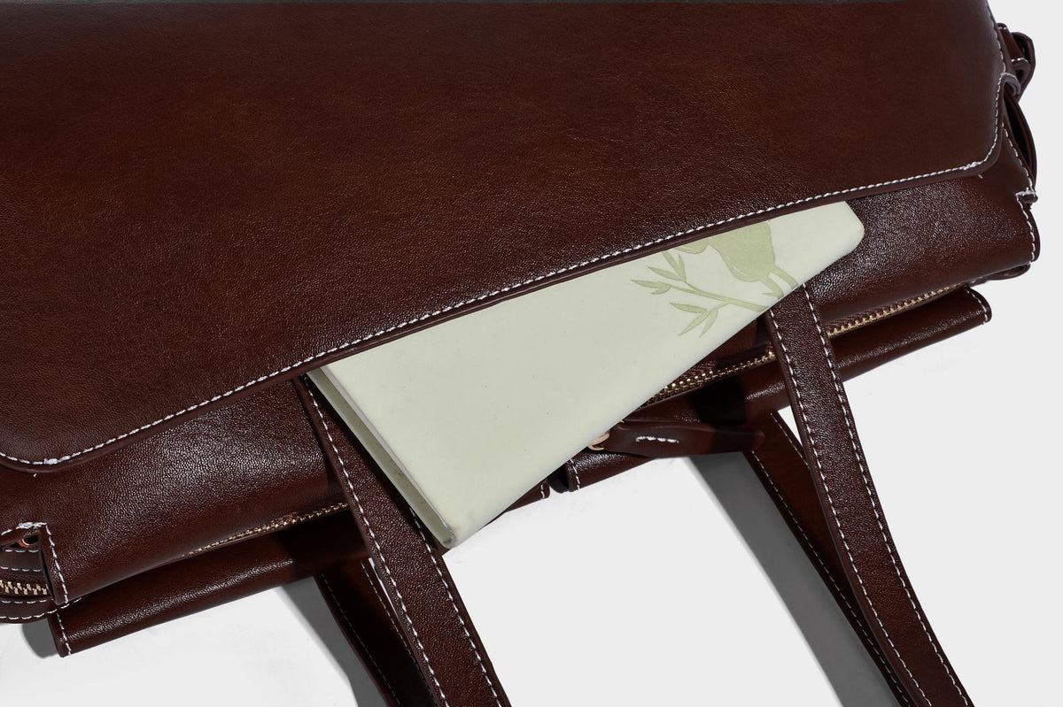Strukturierte rechteckige Baguette-Schultertasche aus dunkelbraunem Material in glatter Lederoptik mit zwei Riemen und Reißverschluss oben
