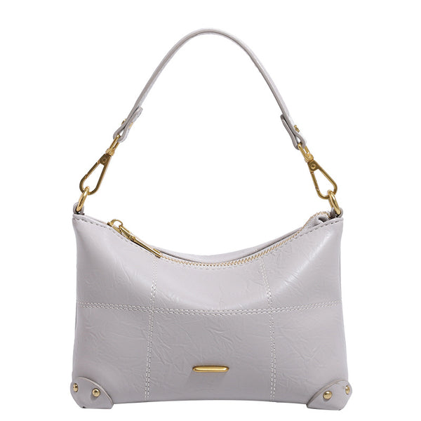 Small soft-structured shoulder bag with curved zip closure, stitched panel detailing, and gold-tone hardware, detail view 5