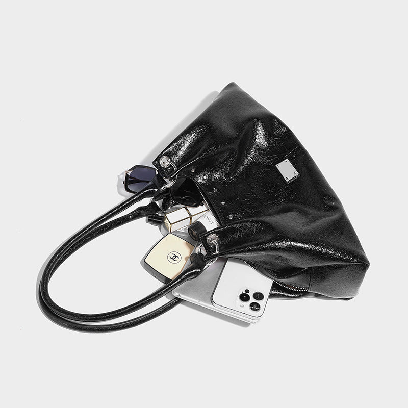 Lässig fallende Tote-Schultertasche in Trapezform mit glänzender, geknautschter Lederoptik, zwei geschlungenen Henkeln, Reißverschluss oben und