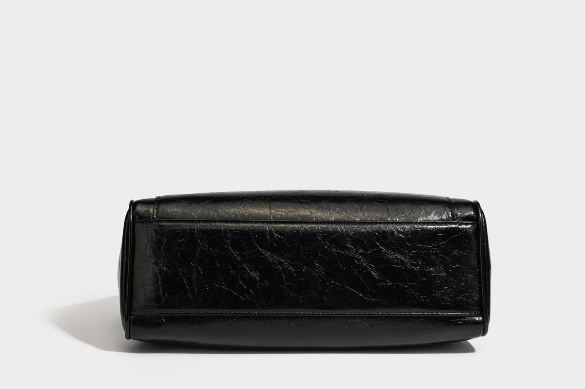 Structured glossy crinkled leather-look satchel with double top handles, front metal-plaque tab, silver-tone hardware, and