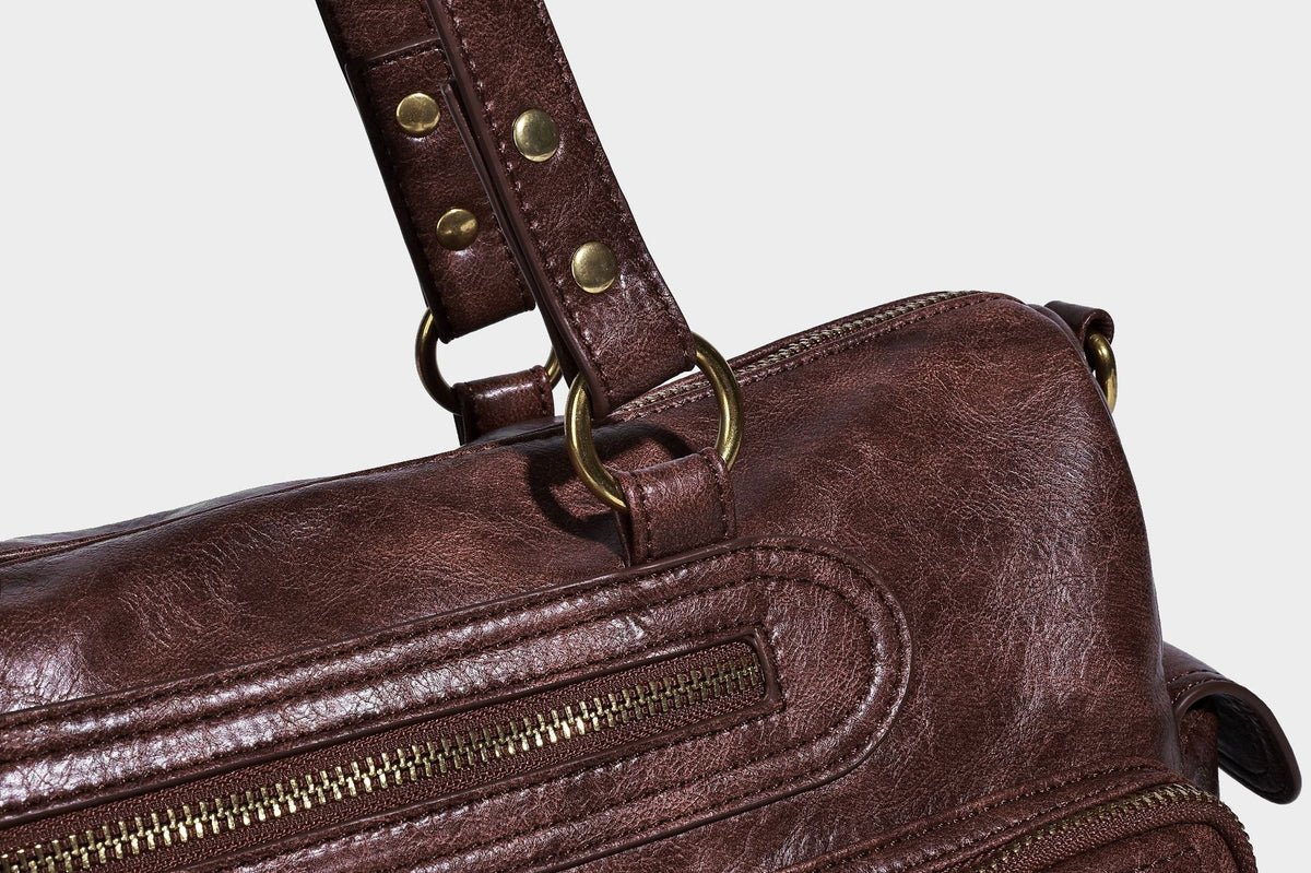 Distressed leather-look vintage satchel shoulder bag with multiple front zip pockets, dual top handles, and brass-tone