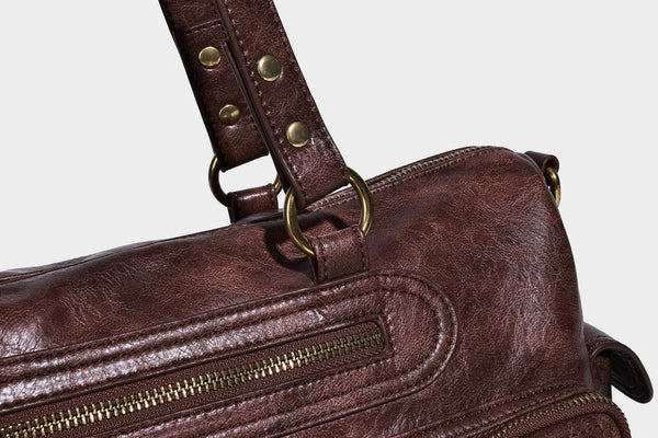 Distressed leather-look vintage satchel shoulder bag with multiple front zip pockets, dual top handles, and brass-tone