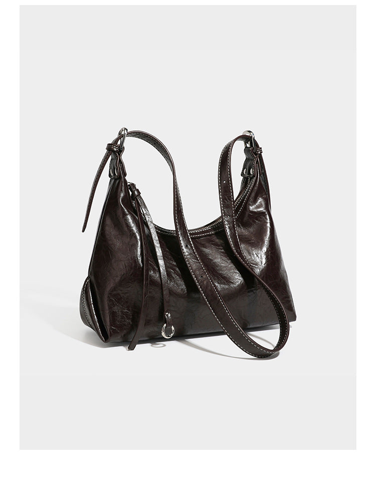 Slouchy hobo shoulder bag in glossy crinkled leather-look finish with zip-top closure and silver-tone ring hardware, detail