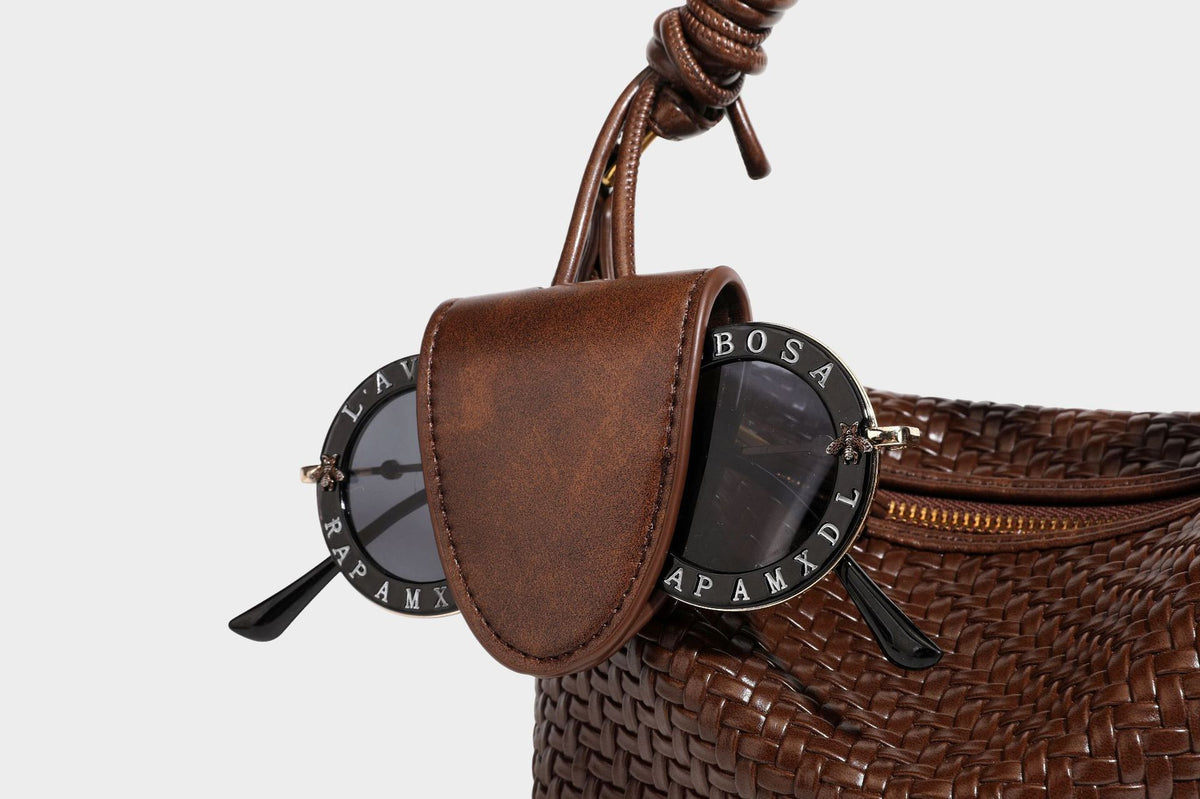 Small glossy basket-weave hobo shoulder bag in brown with knotted top handle, flap accent pocket, and gold-tone hardware