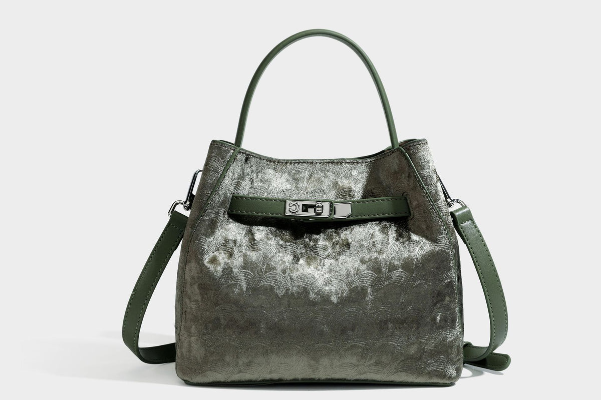 Small structured bucket satchel in embossed velvet-texture fabric with silver turn-lock hardware, rounded top handle, and