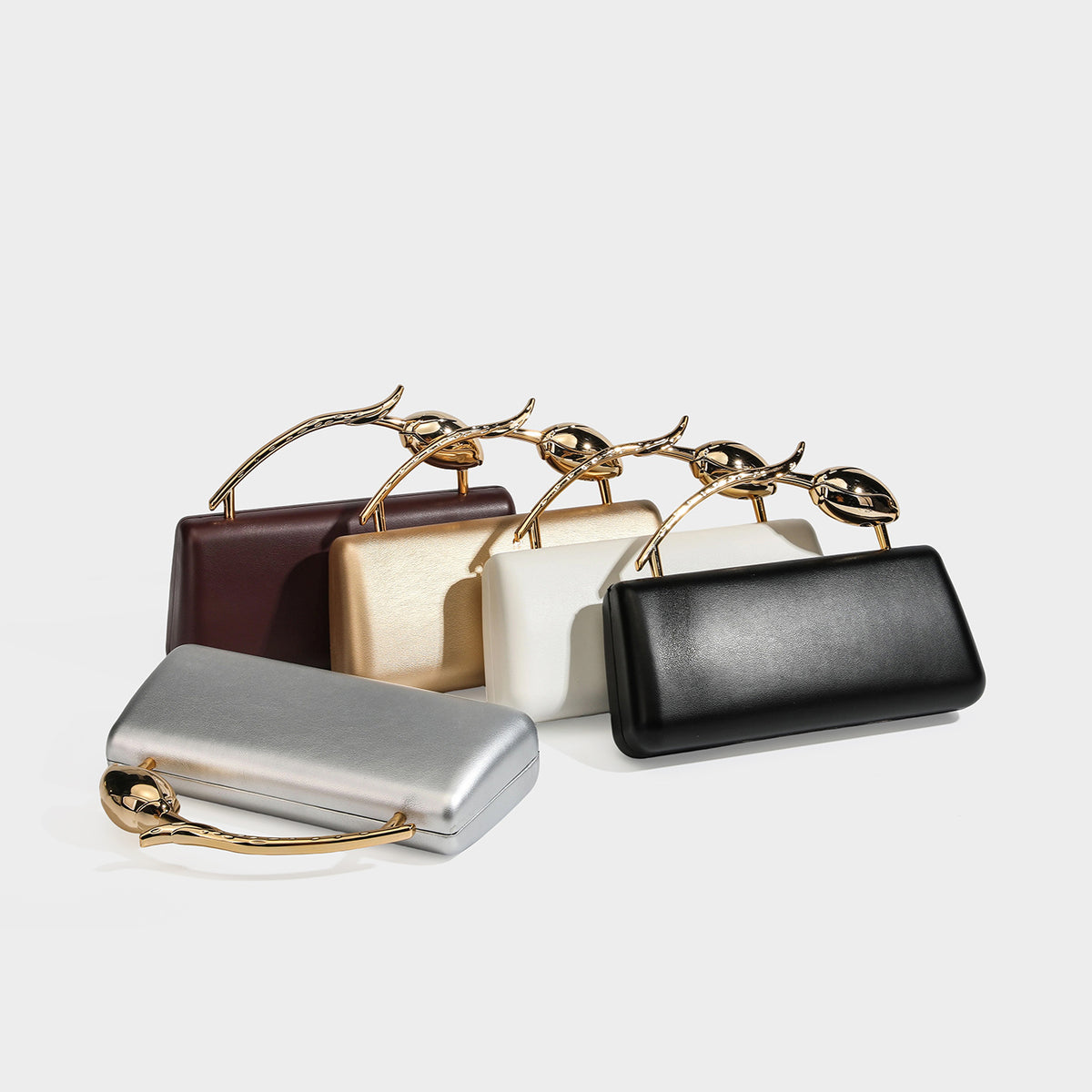 Structured rectangular clutch bag with gold-tone rose-bud top handle and detachable chain strap in metallic finish, detail